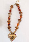 Necklace with heart-shaped pendant and brown beads on a white background