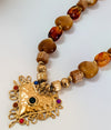 Necklace with gold heart pendant and amber beads on a white background