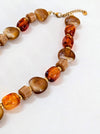 Necklace with brown and orange beads on a white background