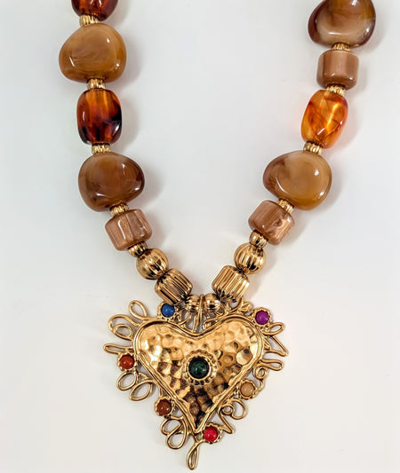 Necklace with heart-shaped pendant and amber beads on a white background