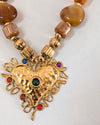 Necklace with gold heart pendant and brown beads on a white background