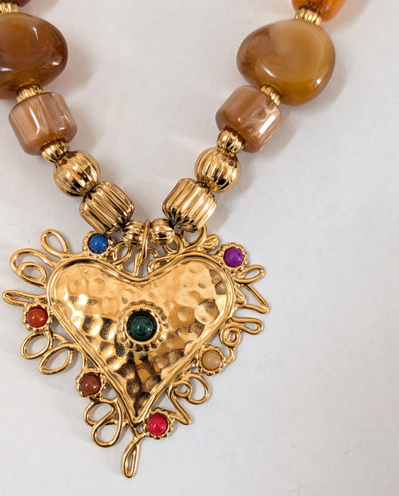 Necklace with gold heart pendant and brown beads on a white background