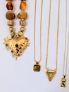 Three gold necklaces with various pendants on a white background