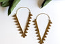 Pair of gold hoop earrings with leaf-like designs on a white background